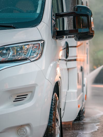 a man washing the exterior of his motorhome as part of his RV maintenance checklist